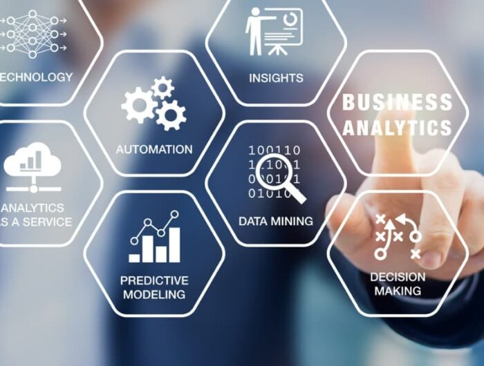 A blurred image of a man in a business suit with a finger extended that has hexagons with the word technology, analytics as a service, automation, predictive modeling, data mining, business analysis, and decision making superimposed – all to indicate the importance of predictive analytics in claims management.