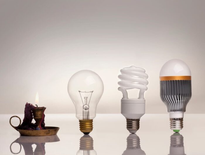 The evolution of light showing a candle, an incandescent bulb, a fluorescent bulb, and finally an LED bulb.